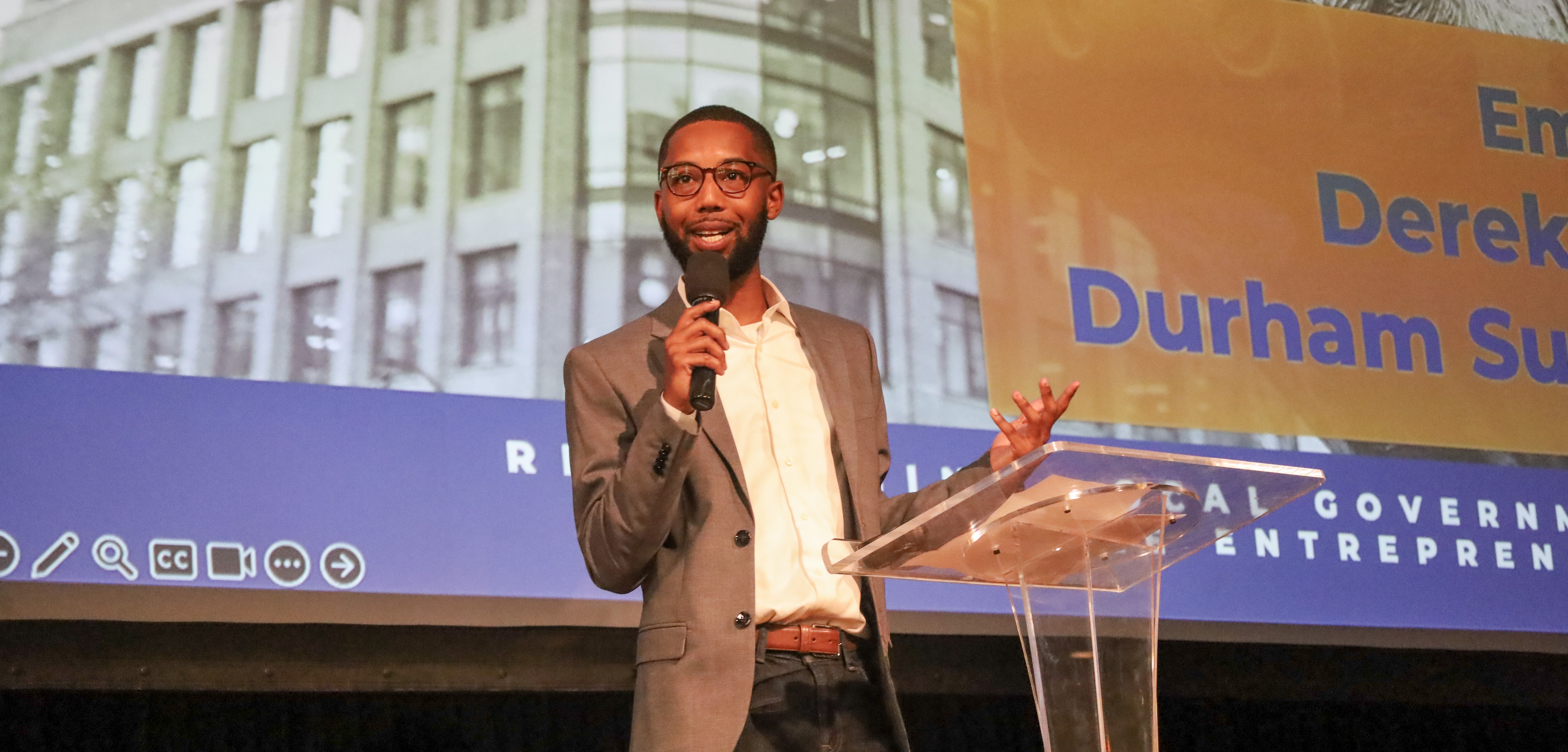 Speaker with microphone at Innovate Durham Demo Day event
