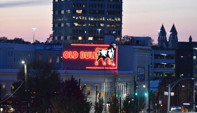 Old Bull neon sign lit up in downtown Durham.