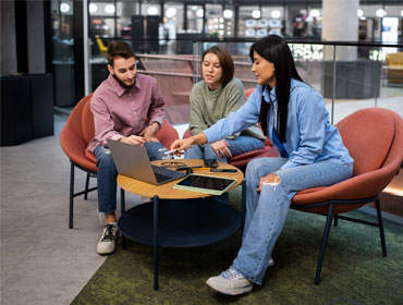 2 girls and 1 boy working on a laptop
