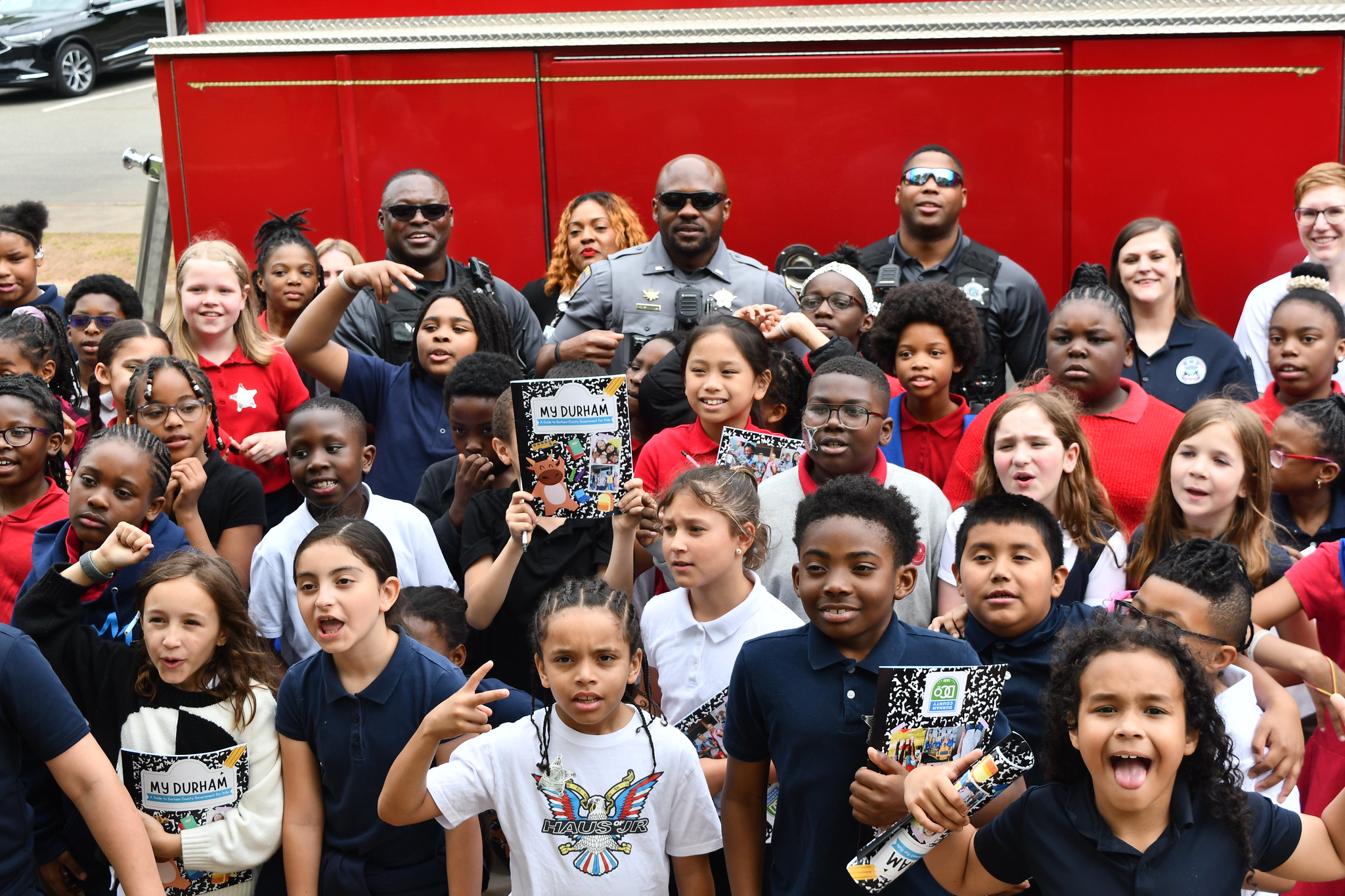 Kids in front of firetruck with County Workers