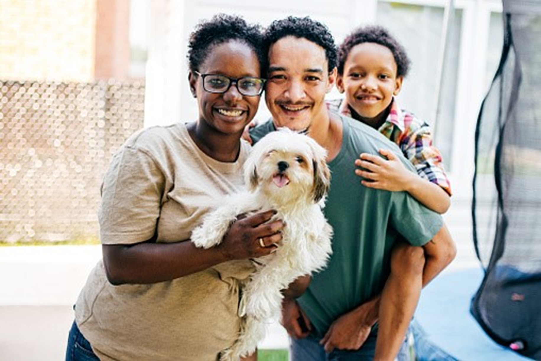 A family of three holding a dog