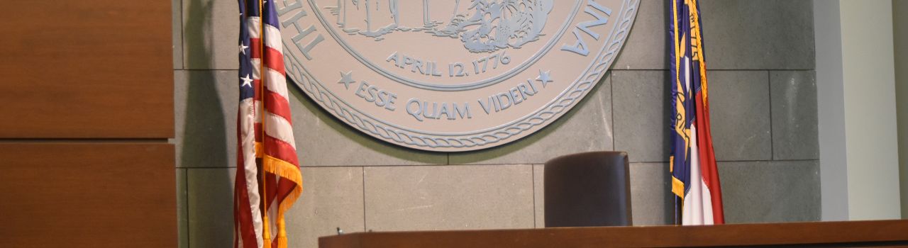 courtroom view of judge's chair and flags and state seal
