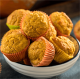 Pumpkin Muffins stacked in a bowl.