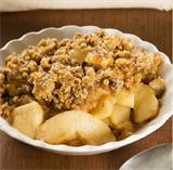 Warm apples in a dish covered with crumble.