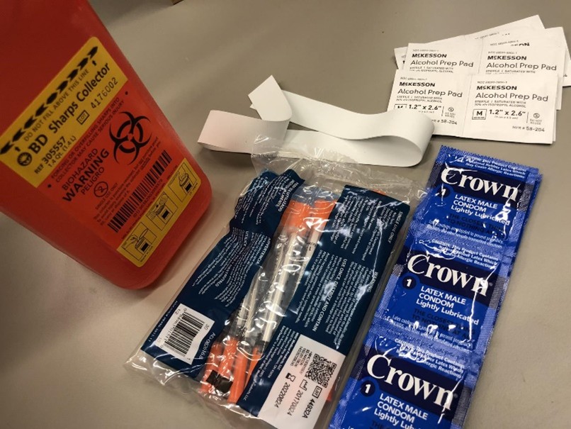 Syringes, a sharps disposal container, and condoms