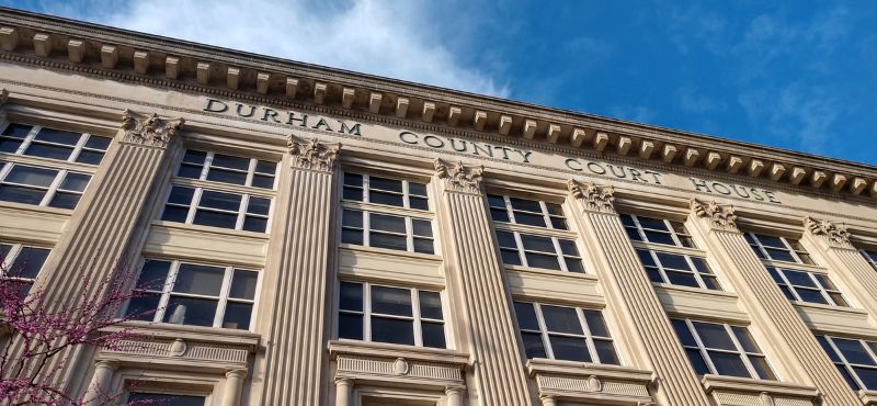 A blue sky is above the old Durham County Court House, now the Administration I Building.