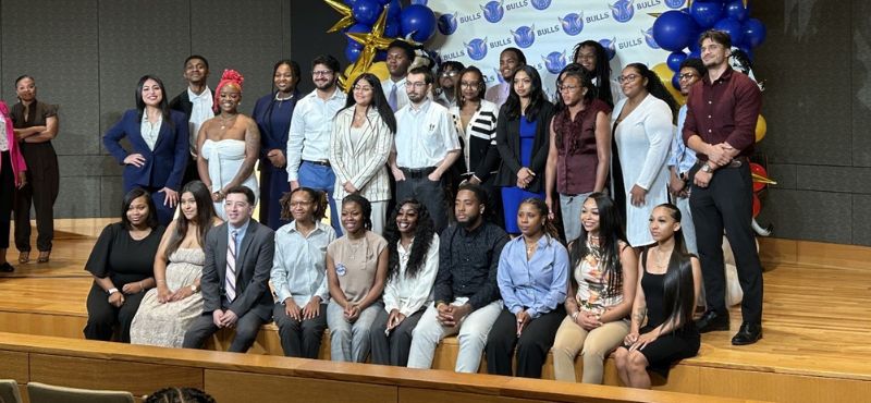 The graduates of the BULLS Life Sciences Academy pose for a photo on stage.