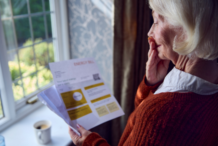 elderly woman looking at bill