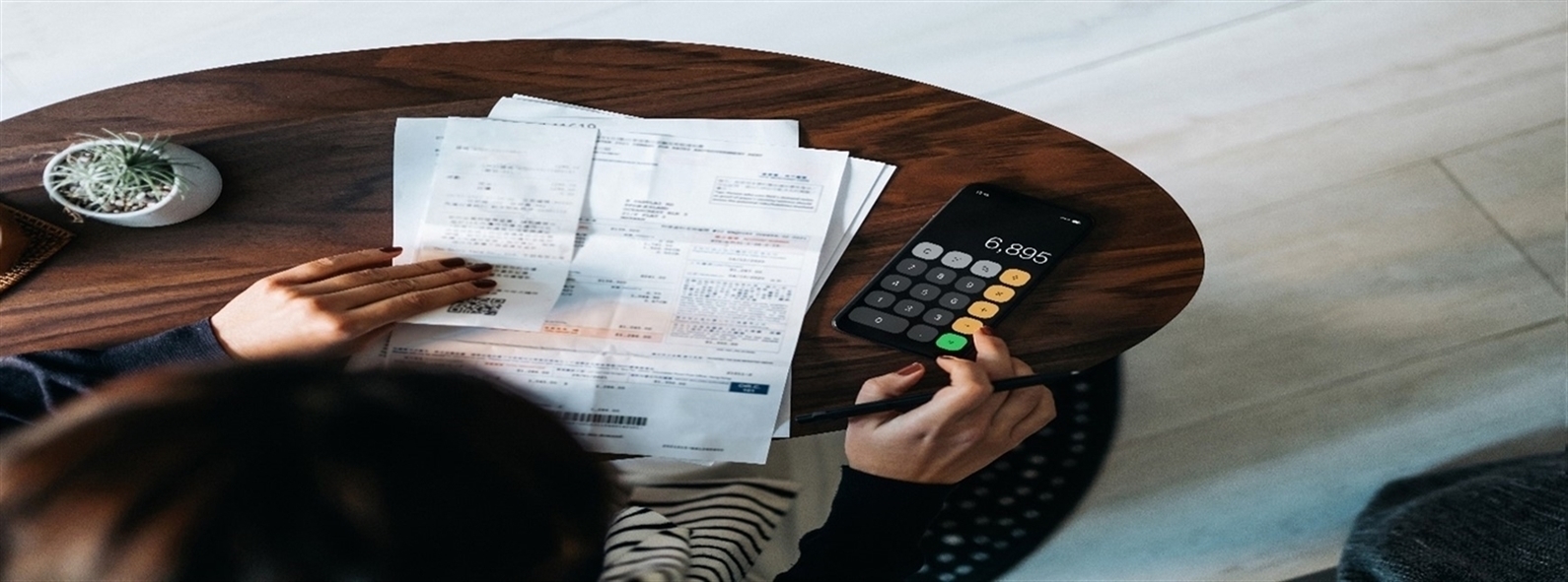 Person at table with papers and calulator