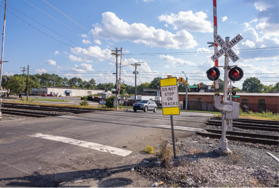 Crossing arm and signage, including a sign that says “do not stop on tracks,” at South Driver Street.