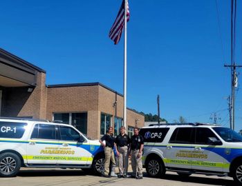 Community Paramedics by US Flag and Vehicles